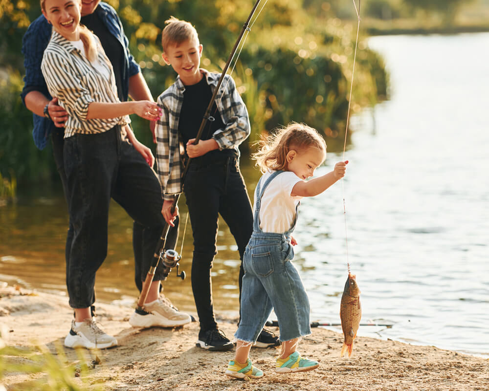 famille qui pêche au bord d'un lac